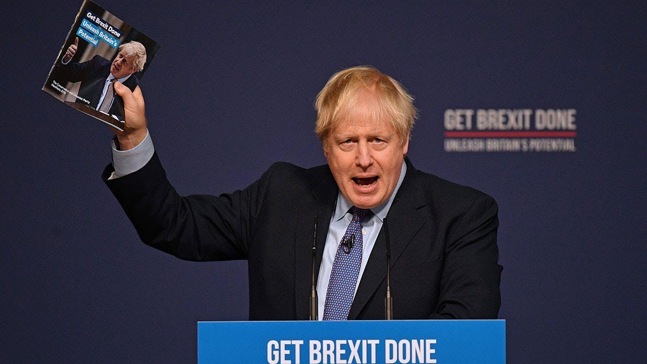 Boris Johnson holding up the 2019 manifesto