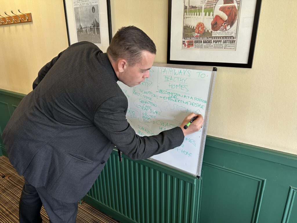 Sefton Metropolitan Borough Councillor, James Hansen takes notes ahead of his presentation on healthier homes to the group