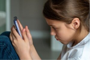 Labour's social media ban would affect children under 16, such as the girl looking at her phone in this image.